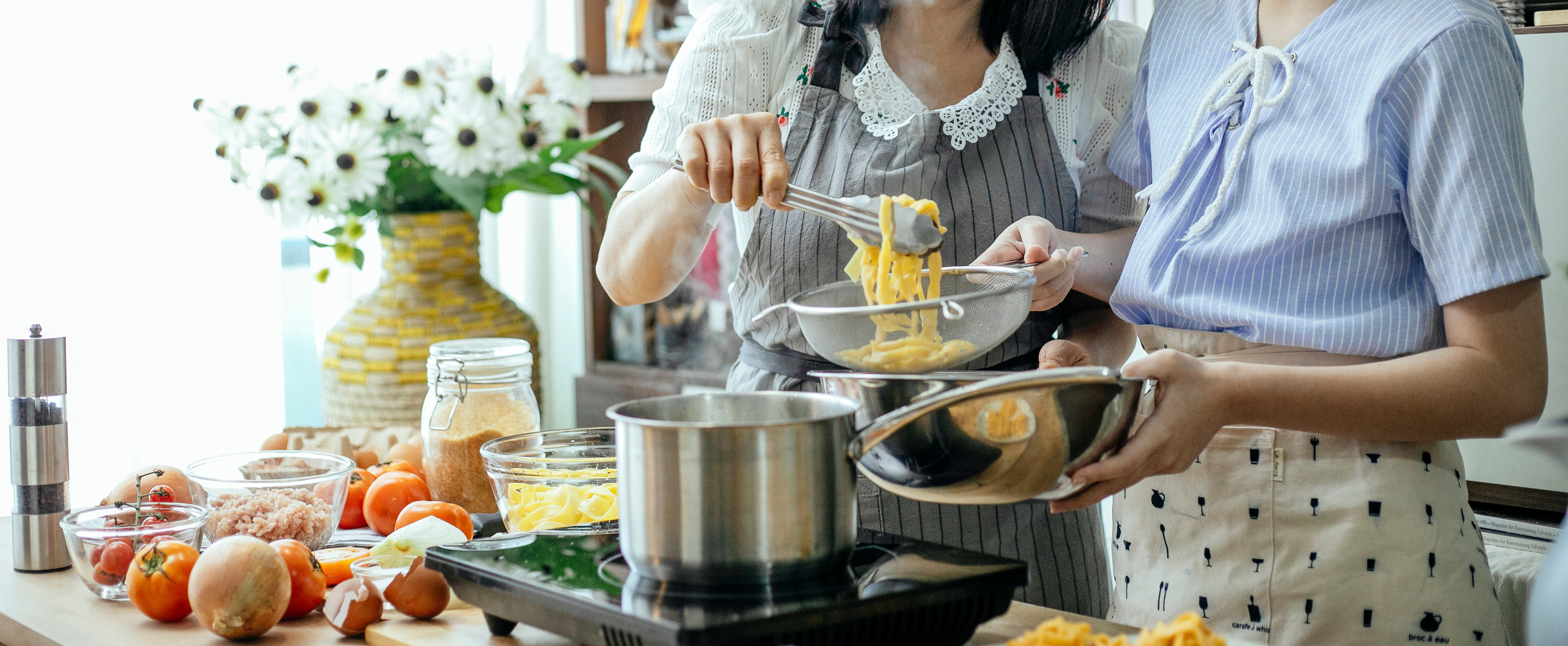 Crop women cooking pasta in kitchen